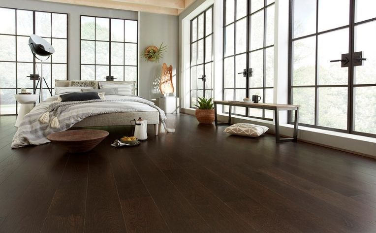 Dark wood floors in a spacious bedroom.